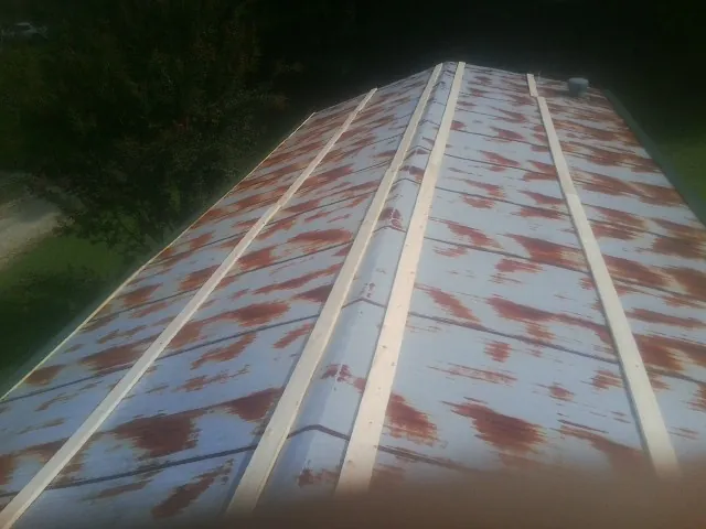 Rusted metal roof panels with new wood purlins before replacement — Storm Damage Roof Repair in Adamsville by Roofing Brothers