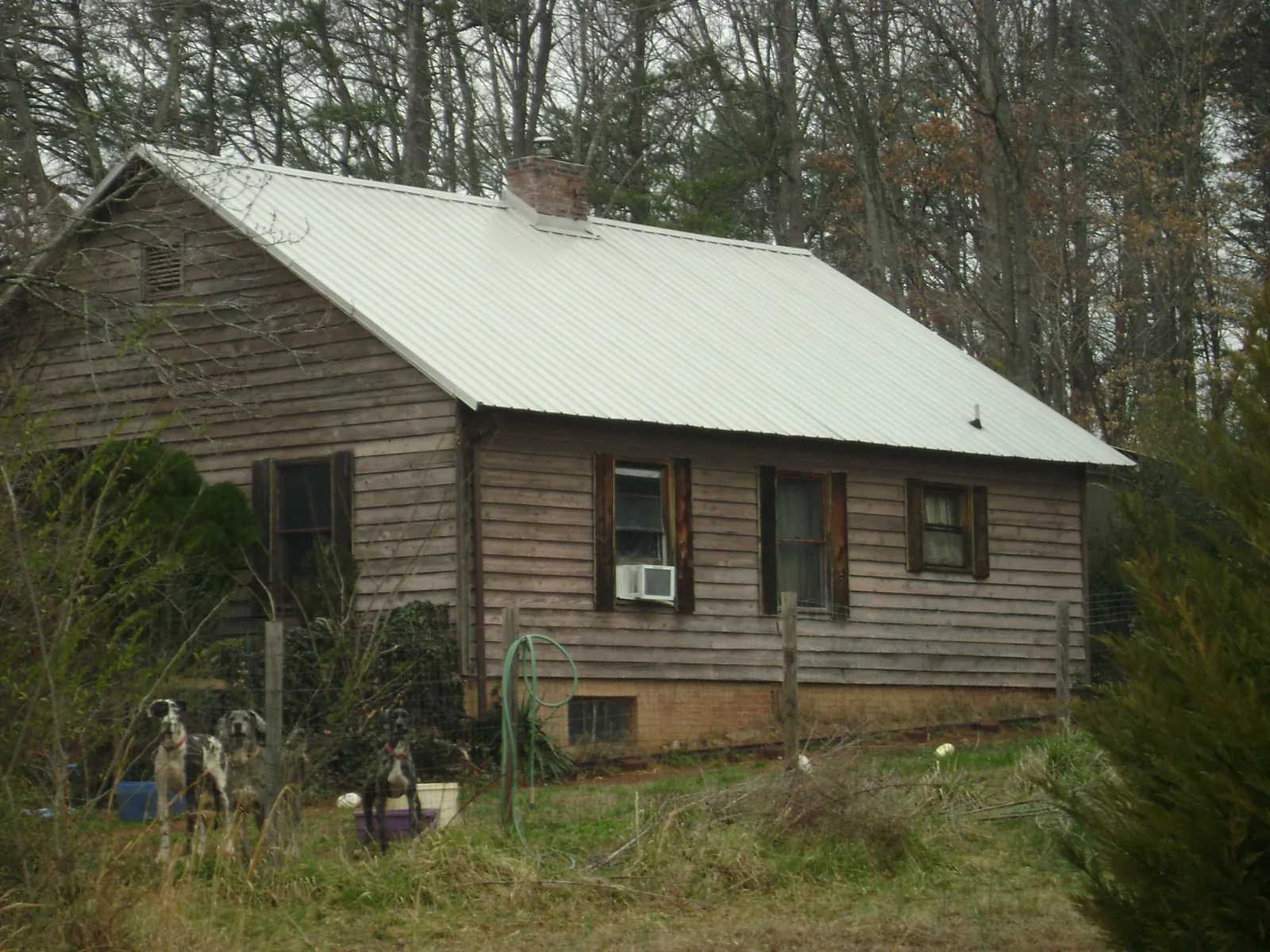 White metal roof on an old wood sided farmhouse, from a Metal Roof Installation job in Adamsville